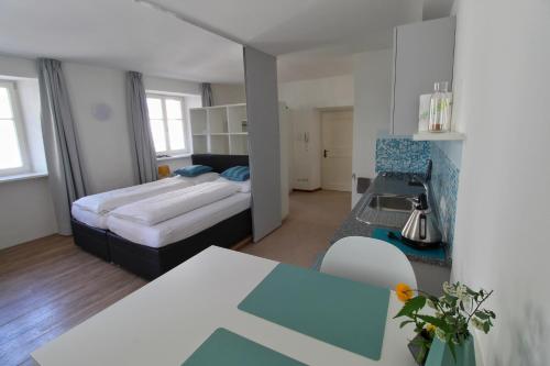 1 dormitorio con 1 cama y cocina con mesa en Maria von Buol - Wohnen in Kaltern, en Caldaro