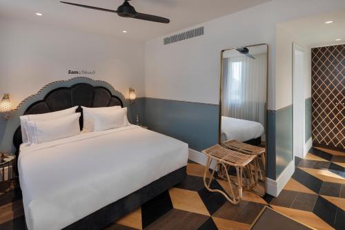 a hotel room with a large bed and a table at Sam&Blondi in Tel Aviv