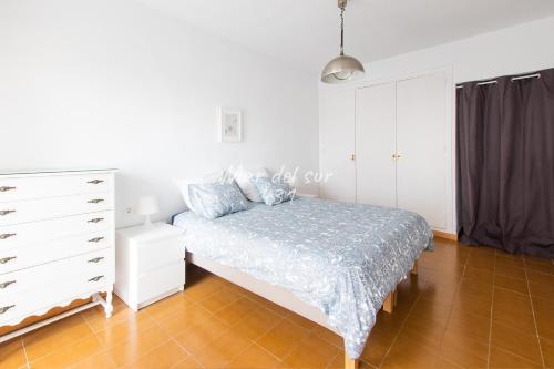 a white bedroom with a bed and a dresser at Mar del Sur Apartamentos- Piscina y Playa - PARKING GRATIS in Benalmádena