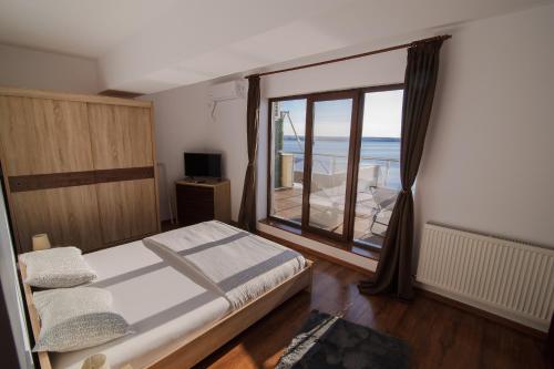 a bedroom with a bed and a large window at Sea Gem Mamaia - 200m to Beach, XL Terrace, and Beautiful Views in Mamaia