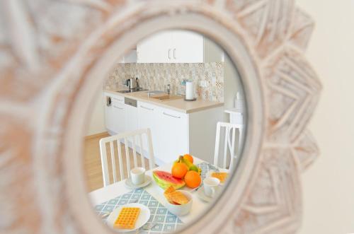 シュチルクにあるSun&Sport Apartament TURKUS w super lokalizacji niedaleko wyciąguの鏡に映った果物が置かれたテーブルのあるキッチン