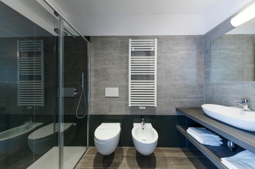 ein Badezimmer mit zwei Waschbecken, einem WC und einer Dusche in der Unterkunft Hotel Sole Holiday in Arco