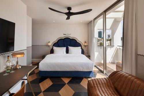 a bedroom with a large bed and a living room at Sam&Blondi in Tel Aviv