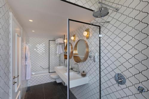 een badkamer met een wastafel, een toilet en een spiegel bij Sam&Blondi in Tel Aviv