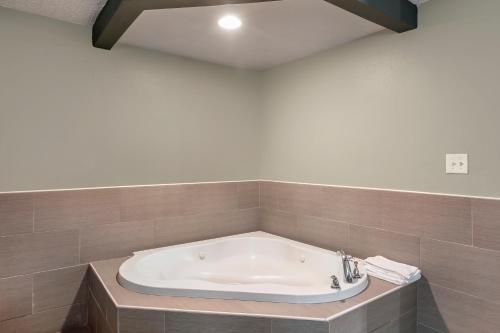 a bath tub in a bathroom with a sink at Knights Inn Bristol in Levittown