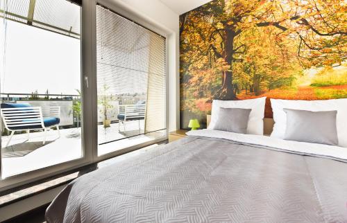 a bedroom with a bed and a large window at APARTAMENT CENTRUM - 2 z miejscem parkingowym in Toruń
