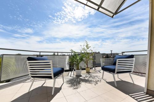 two chairs on a balcony with a view of the sky at APARTAMENT CENTRUM - 2 z miejscem parkingowym in Toruń