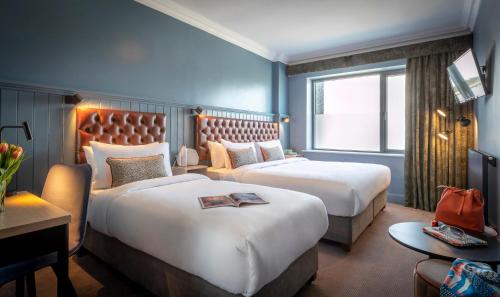 a hotel room with two beds and a television at Shoreline Hotel in Donabate