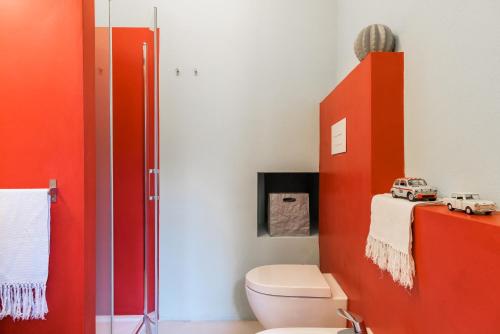 bagno con servizi igienici e armadietto rosso di Duomo Luxury Suite - by MyHomeInComo a Como