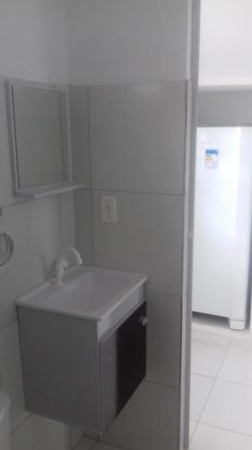 La salle de bains blanche est pourvue d'un évier et d'un réfrigérateur. dans l'établissement Casa da Árvore, à Porto de Galinhas
