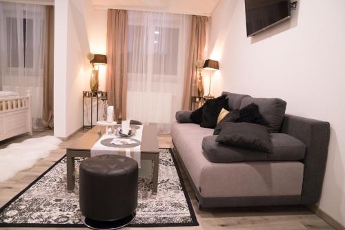 a living room with a couch and a table at Pension & Restaurant La Amalia in Bad Sauerbrunn