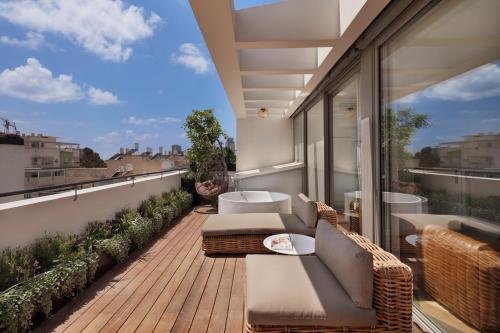 a balcony with wicker furniture and a view of the city at Sam&Blondi in Tel Aviv