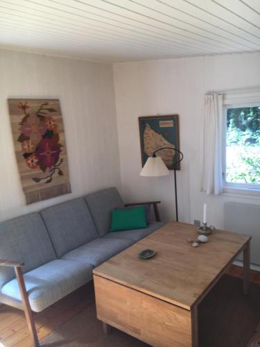 a living room with a couch and a table at Midtvejshuset in Rønne