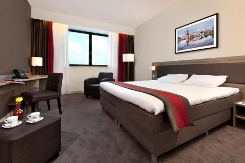 a hotel room with a bed and a desk at Fletcher Hotel-Restaurant Wings-Rotterdam in Rotterdam