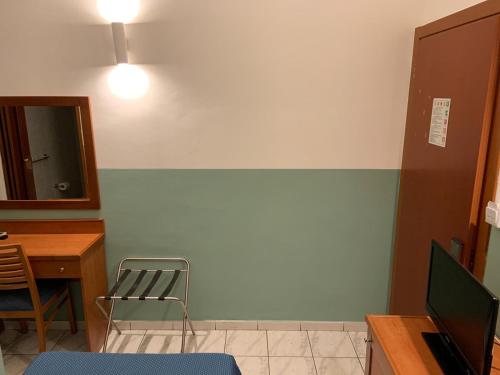 a room with a desk and a chair and a mirror at Hotel Lungomare in Reggio Calabria