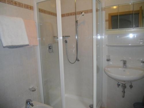y baño con ducha y lavamanos. en Garni Margherita, en Corvara in Badia