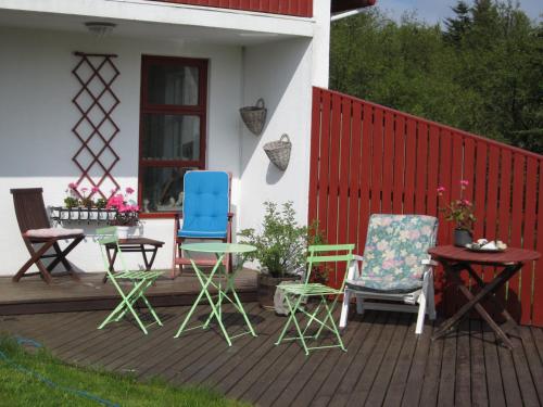 un grupo de sillas y mesas en una cubierta en Úlfarsfellsvegur 20, 113 Rvk Birkihlid en Reikiavik