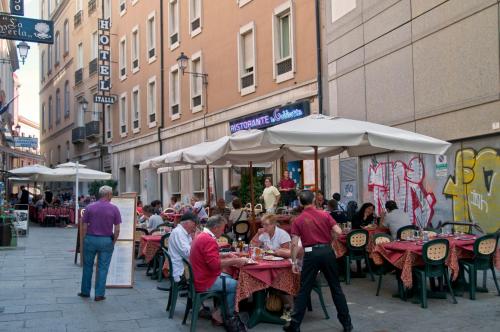 a group of people sitting at tables at an outdoor restaurant at Hotel Italia in Cagliari