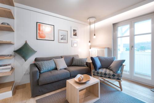 a living room with a couch and a table at LOEV - VELA Hotels in Binz