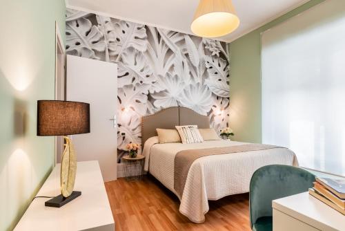 ein Schlafzimmer mit einem Bett und einem Wandbild in der Unterkunft Fior Di Loto Rooms in Cagliari