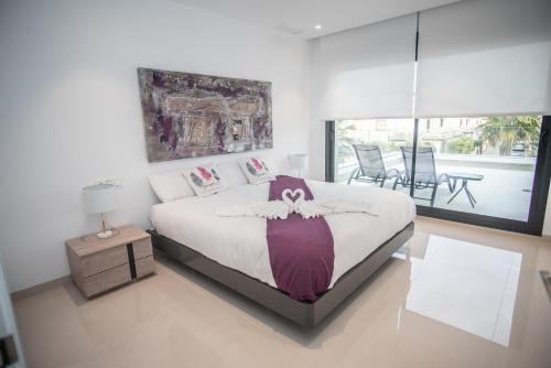 1 dormitorio con 1 cama y 1 mesa con sillas en Villa Deluxe La Marina Beach, en Alicante