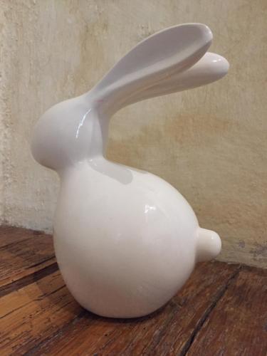 a white bird vase sitting on a wooden floor at Quinta Luna in Cholula