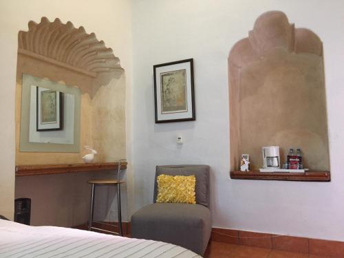 a bedroom with a chair and a mirror at Quinta Luna in Cholula