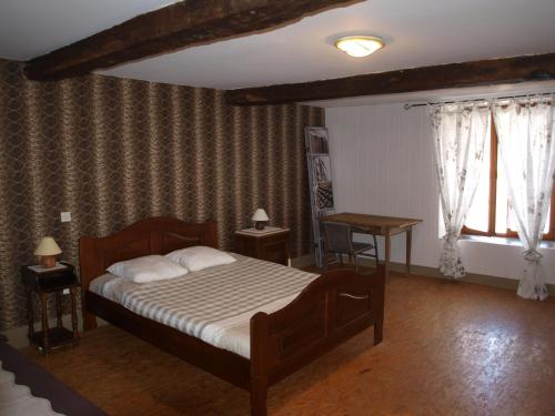 sypialnia z łóżkiem, 2 stołami i oknem w obiekcie GITE ANNA w mieście Le Châtelet-sur-Sormonne