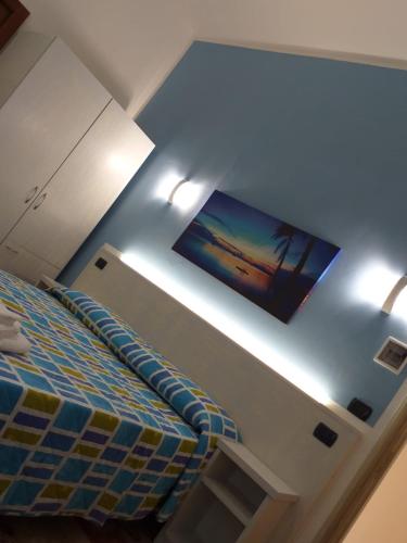 a bedroom with a bed and a flat screen tv at B&B L'Isola in Porto Cesareo