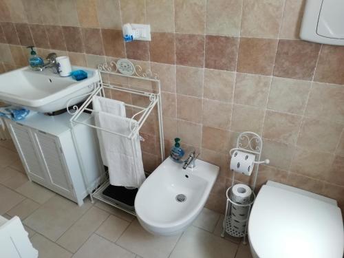 Un baño con un inodoro blanco y un lavabo. en Villa Maria, en Carovigno