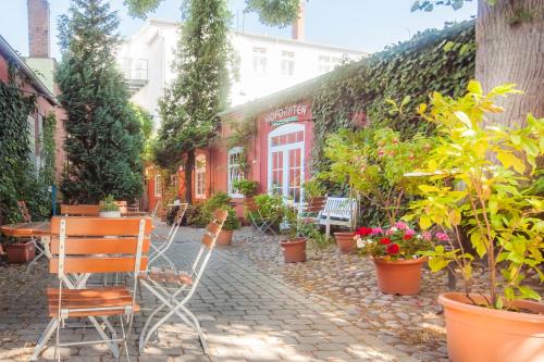a patio with a table and chairs and plants at Hotel Deutsches Haus in Heiligenhafen