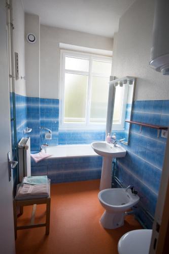 a bathroom with a tub and a sink and a toilet at VILLA BONVOULOIR in Bagnères-de-Bigorre