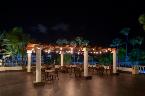 a patio area with tables, chairs and umbrellas at Occidental Punta Cana - All Inclusive Resort - Barcelo Hotel Group "Newly Renovated" in Punta Cana