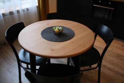 a wooden table with chairs and a hat on it at Simple & Elegant Apartment in Liepāja