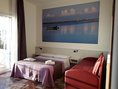 two beds in a room with a large picture on the wall at B&B L'Isola in Porto Cesareo