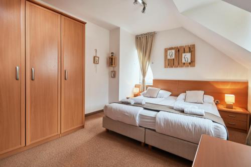 a bedroom with a large bed and wooden cabinets at Rooms & Restaurant Ostarija in Dolenjske Toplice