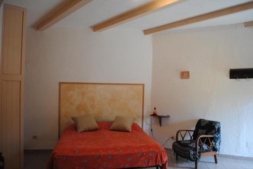 una camera con letto rosso e sedia di Essenza a Pitigliano