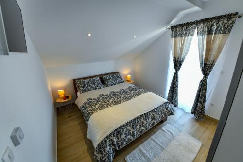 a bedroom with a bed and a large window at CAMBI LUX APARTMENT in Otok