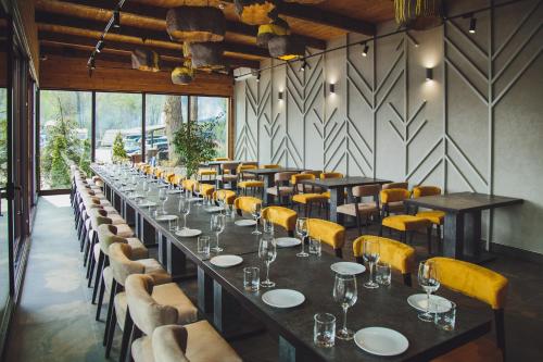 a dining room with long tables and yellow chairs at Hotel Fregat in Kyiv