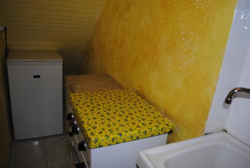 un piccolo bagno con parete gialla e panca di Essenza a Pitigliano