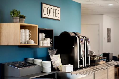 - une cuisine avec une machine à café sur un comptoir dans l'établissement Kyriad Annemasse - Geneve, à Annemasse