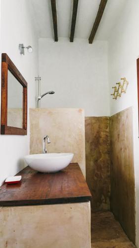 a bathroom with a white sink on a wooden counter at Mawimbi Bungalows in Nungwi