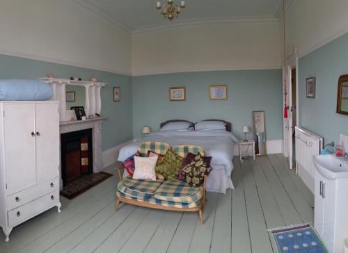 a bedroom with a bed and a chair and a sink at Grantham House in Ryde