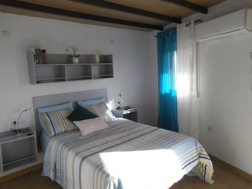 a bedroom with a large bed with blue curtains at Apartamento El Almendrero in El Pueblo