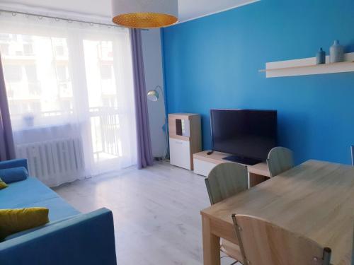 ein Wohnzimmer mit einem Tisch und einem TV in der Unterkunft Apartament Wałbrzych in Wałbrzych