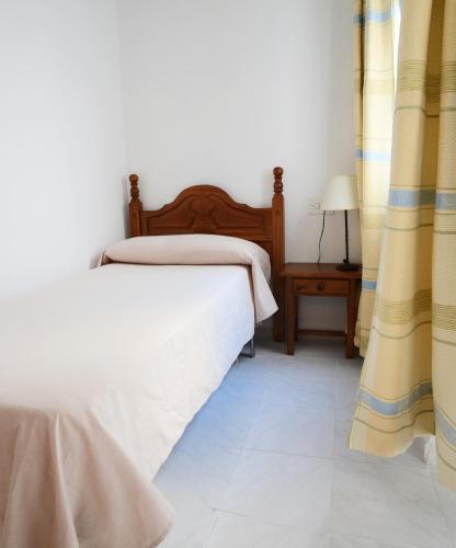 a bedroom with two beds and a table with a lamp at Hotel El Coloso in Jerez de la Frontera