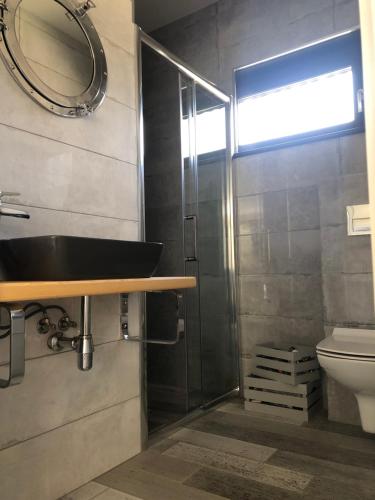 y baño con lavabo y ducha. en Lakehouse Nakielno en Wałcz