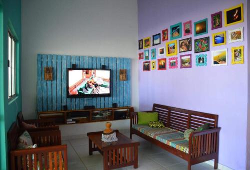 sala de estar con sofá y TV en Espaço Revive Guesthouse e Camping - PÉ NA PRAIA, en Maragogi