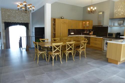 une cuisine avec une table et des chaises dans une pièce dans l'établissement Gite du Domaine de la Maison Neuve, à Saint-Jean-Saint-Germain