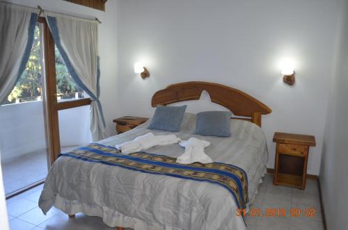 Un dormitorio con una cama grande con toallas. en Apart Bungalows Amulen, en San Carlos de Bariloche